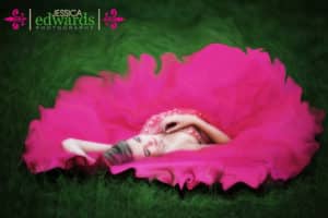 ballerina in pink tutu laying on grass