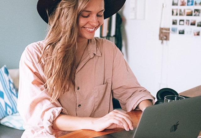 woman smiling while working on laptop