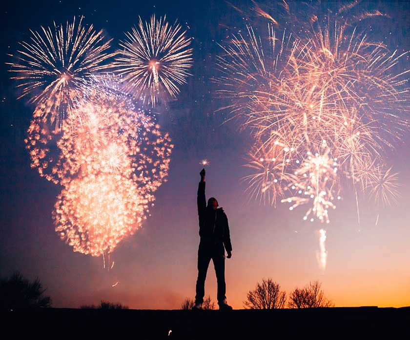person celebrating, silhouetted with fireworks