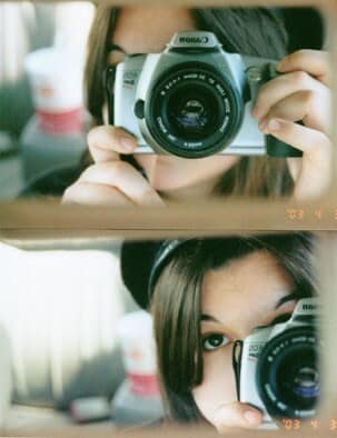 woman reflected in mirror while holding camera