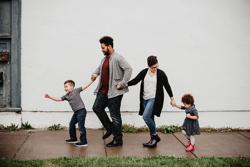 multi-racial family walking on sidewalk