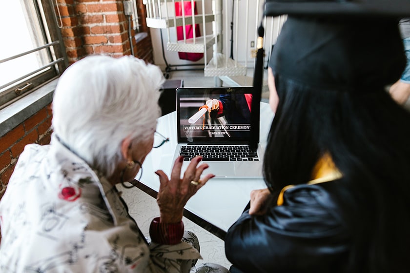 grandmother and graduate attend virtual graduation with laptop
