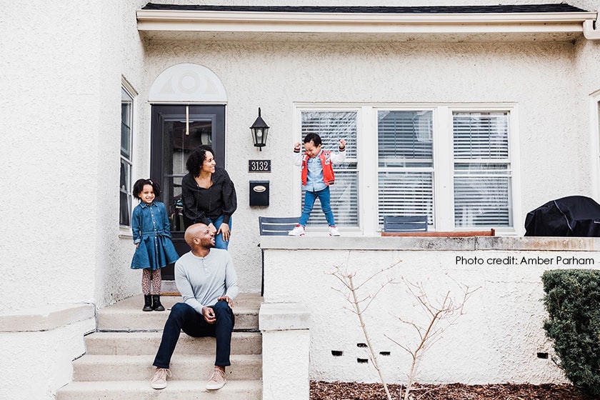 family posed on stucco porch