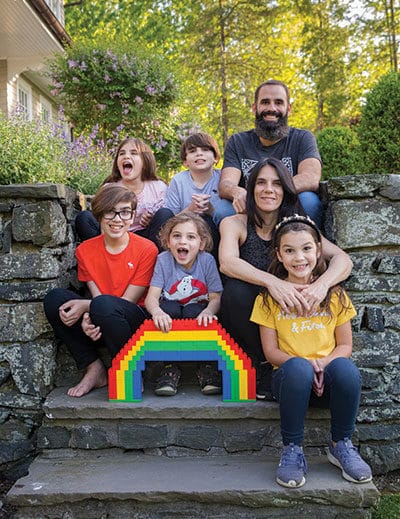 family posed with Lego rainbow on stone steps