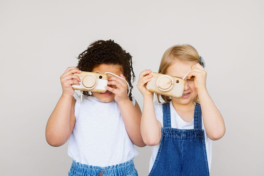 young children holding toy cameras