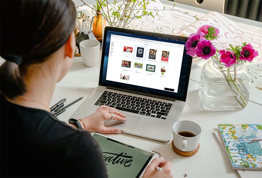 woman using laptop to select holiday cards