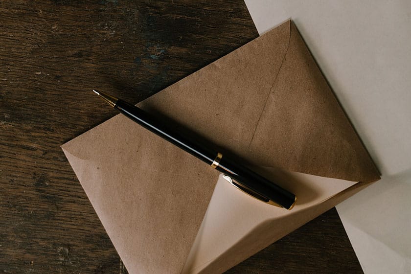 brown kraft paper envelope and pen