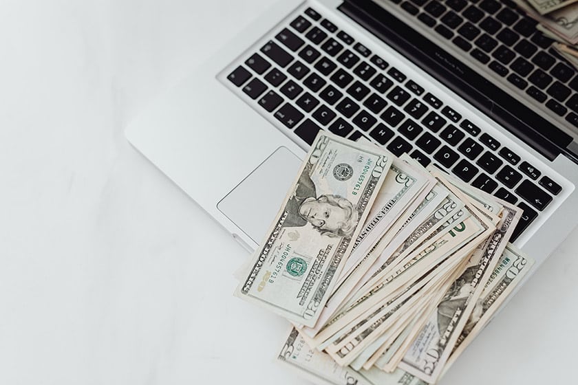 cash lying on laptop keyboard