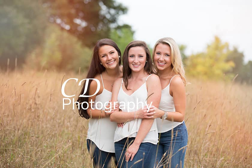 three women in field with watermark across center of image