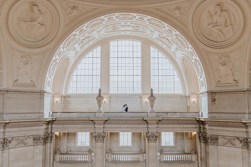 portrait of a wedding couple surrounded by the architectural details of a courthouse