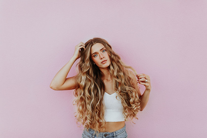 blond woman with long hair in front of a pink studio backdrop