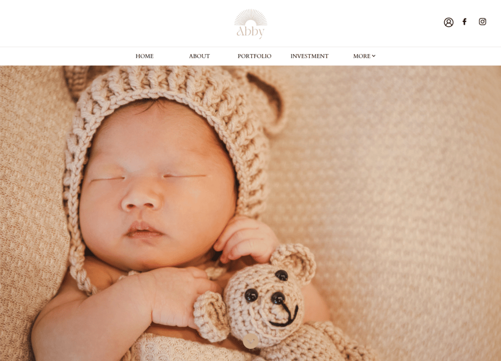 sleeping newborn baby wearing a knit bonnet with bear ears, a crocheted bear toy resting beside it's hands