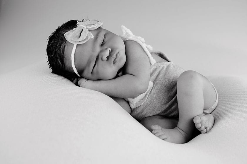 black and white image of a newborn posed on its side