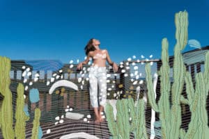 woman leaning against a deck railing, overlayed with paint strokes and illustrated cacti on the left and right of the image