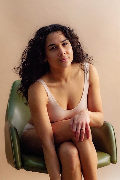 boudoir posed photo of woman sitting with legs crossed