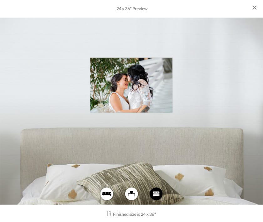 image preview showing the headboard and pillows of a bed with a print of two brides embracing hanging above