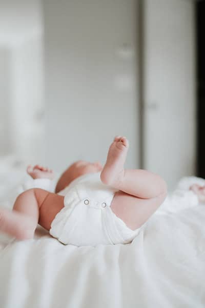 lifestyle newborn portrait with baby on back, the focus on baby's feet