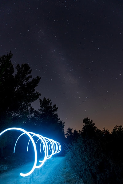 night sky landscape with rings of blue light painting in the foreground