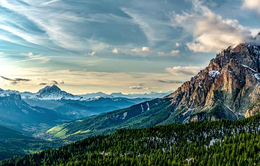 rocky mountains with snow-dusted peaks and green valleys