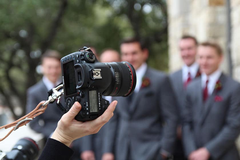 hand of photographer holding camera at wedding