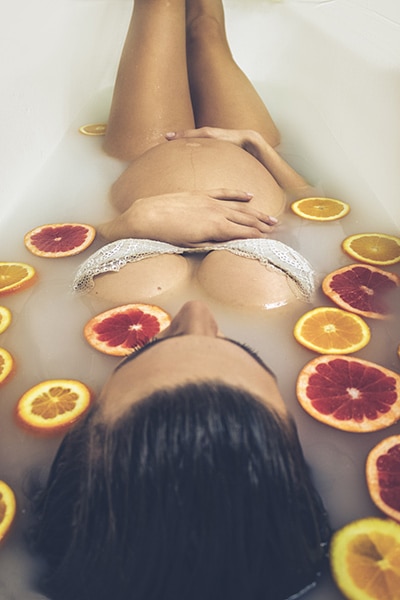maternity boudoir image of woman in bath with fruit