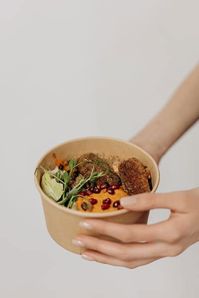 hands holding bowl of food