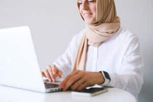 woman wearing headscarf sitting at computer