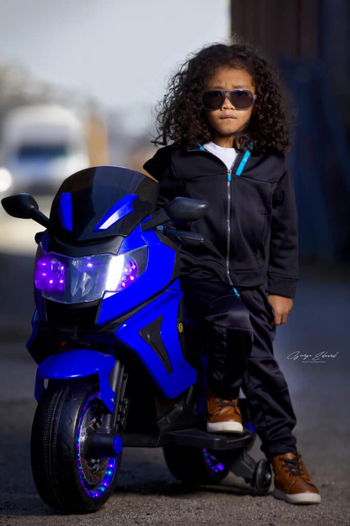 young boy posing with full size toy motorbike photo credit George Edward