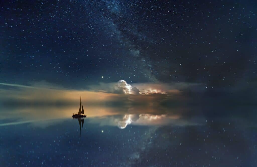 night star and cloud reflection on water with sailboat