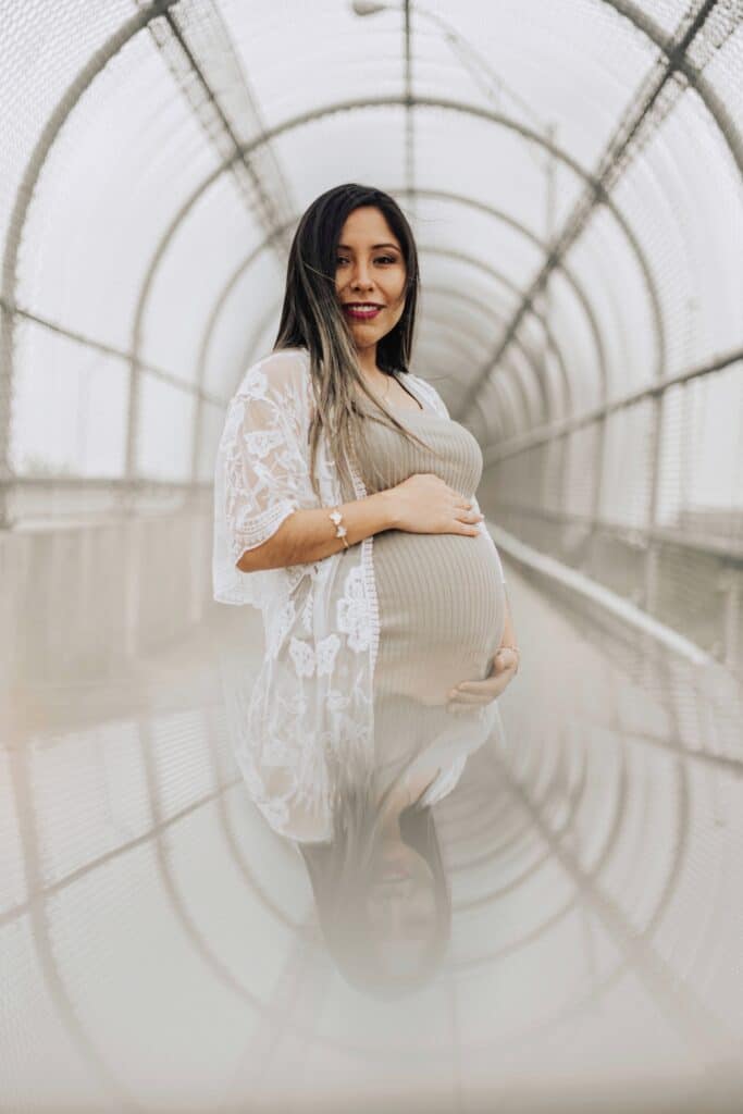 pregnant woman wearing lace shawl and reflected in the lower half of the image