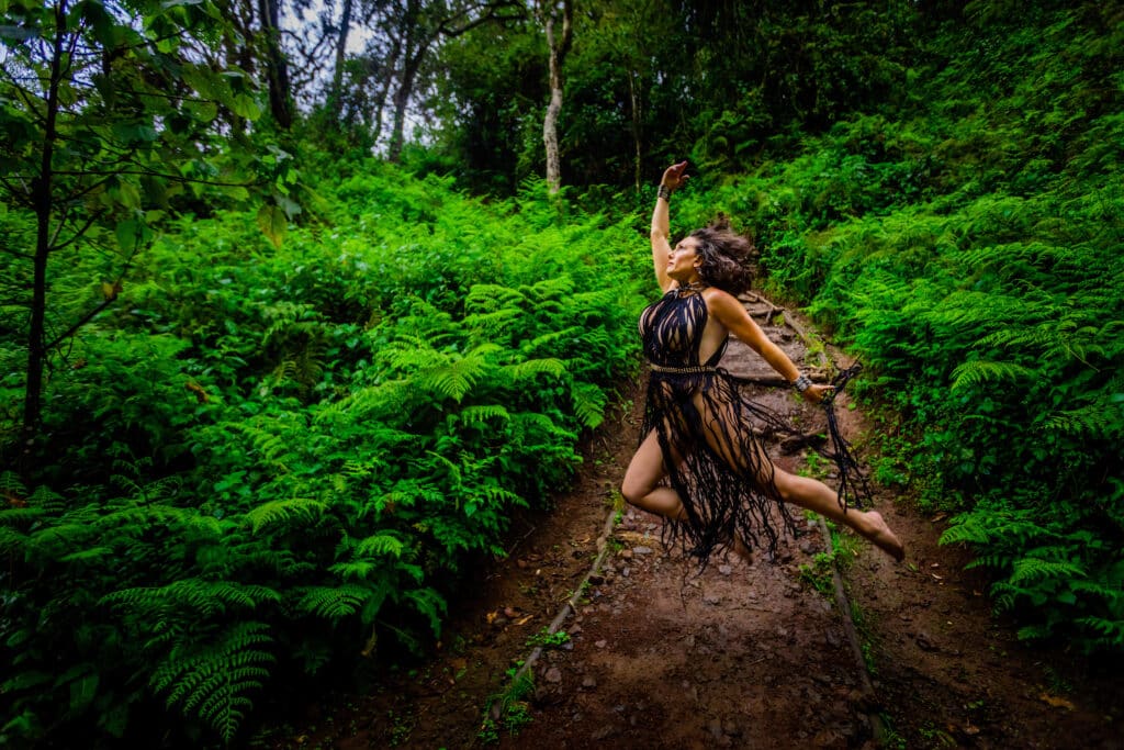Laura Grier kiliminjaro series woman leaping across jungle path