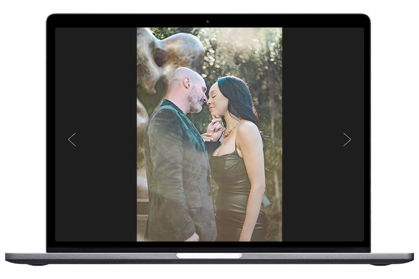 couple standing by statue displayed in a laptop screen photo by Rhonda Dumas