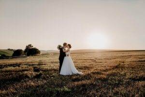 wedding couple portrait in a grassy field near sunset