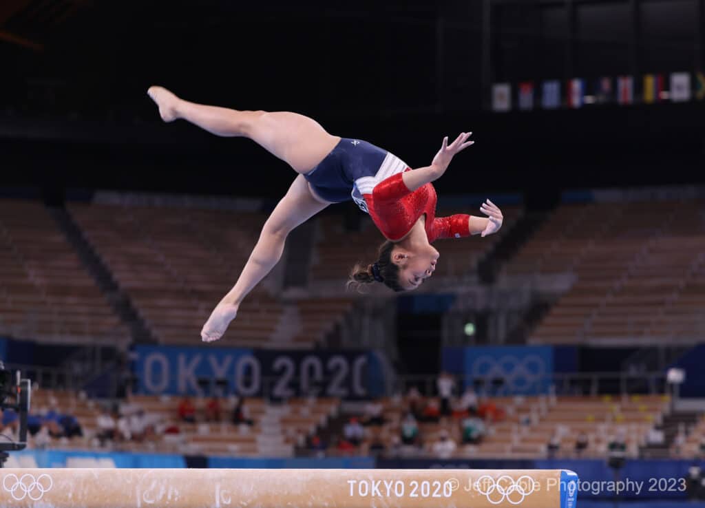 woman doing backflip on bar routine from Olympic Gymnastics Women's team