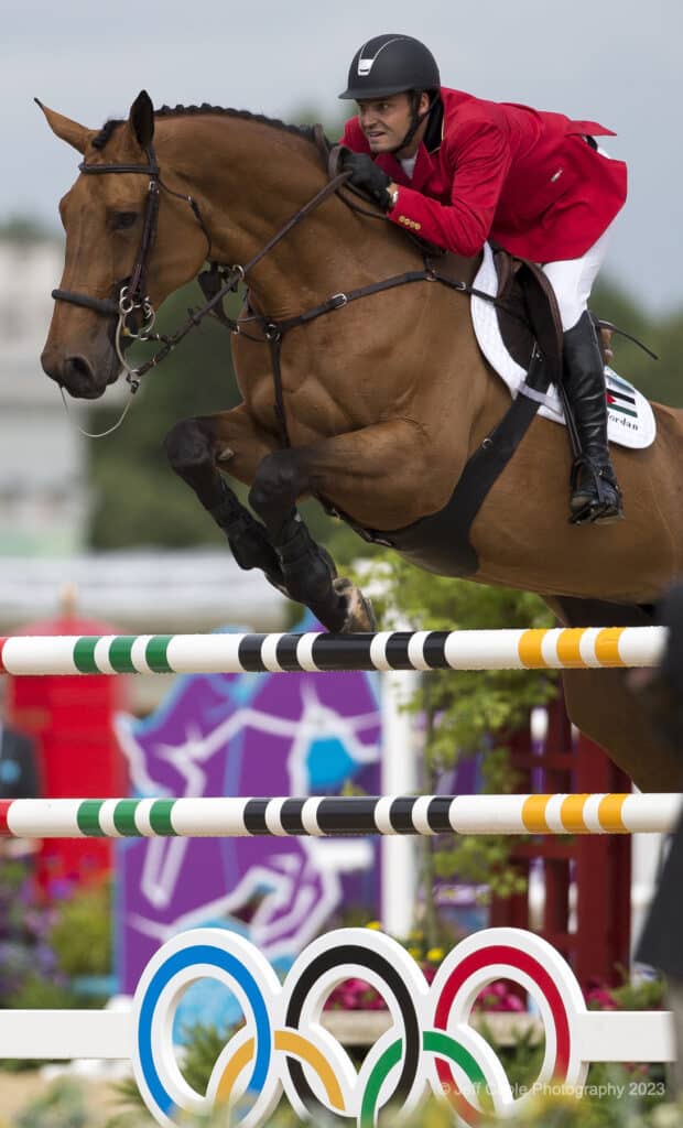 horse and rider jumping bars at olympic equestrian event