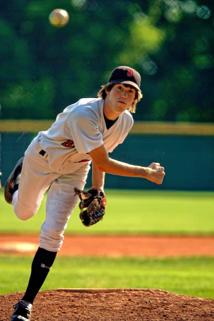 High school baseball player releasing his pitch
