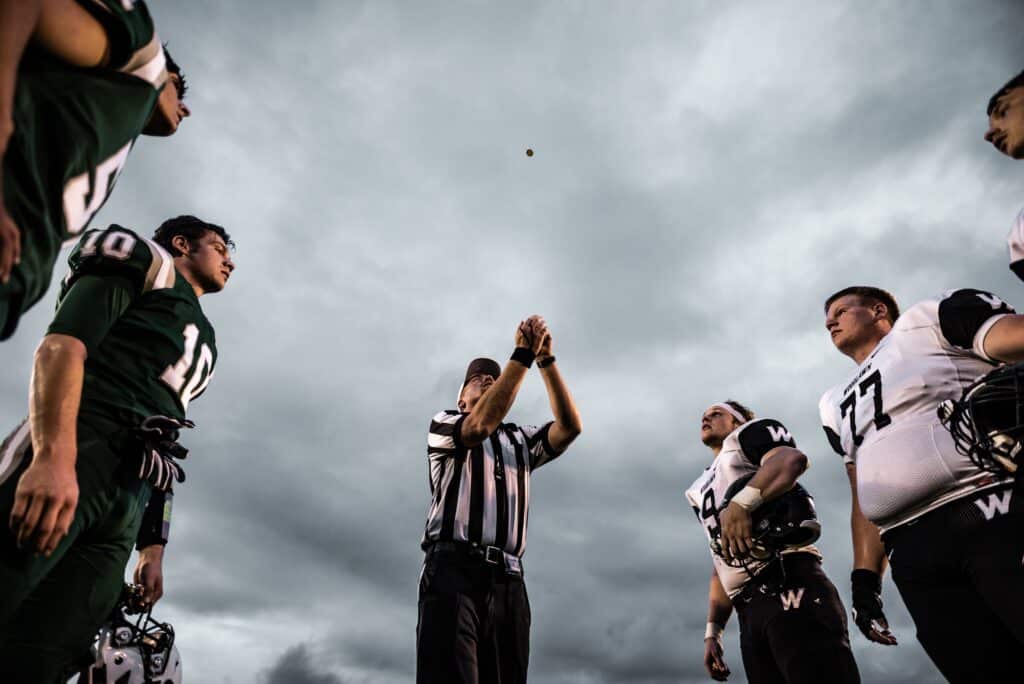 referee doing the coin toss to begin an american football game