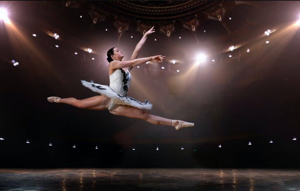 ballet dancer mid-leap, legs in a split