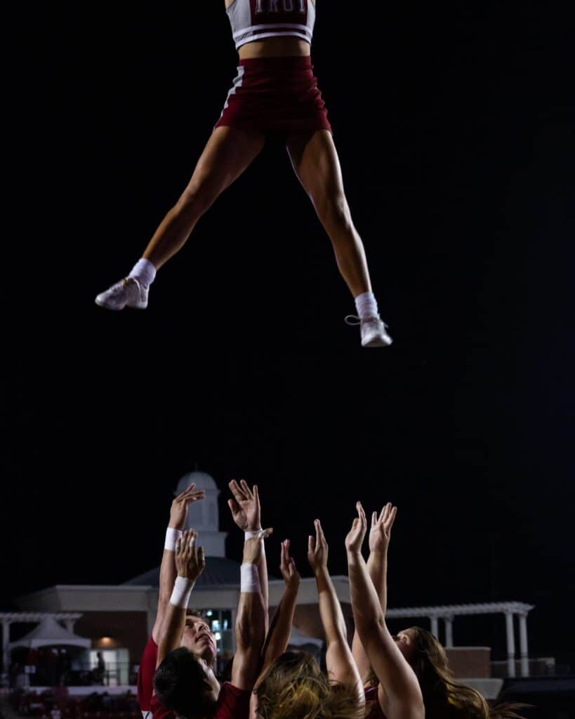 cheerleader in air at night game