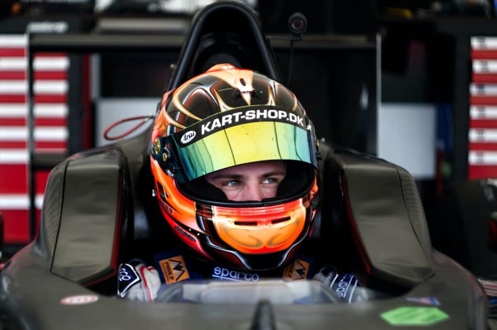 race driver in racing car wearing helmet