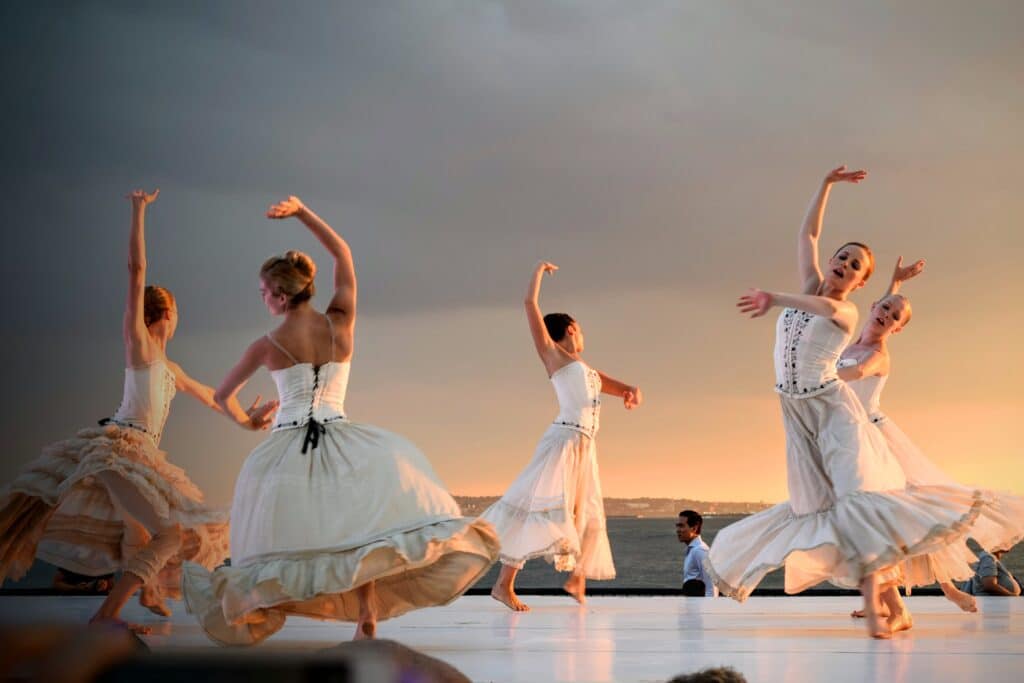 female dancers wearing flowing white skirts performing dance called “Undamely” at Battery Dance festival
