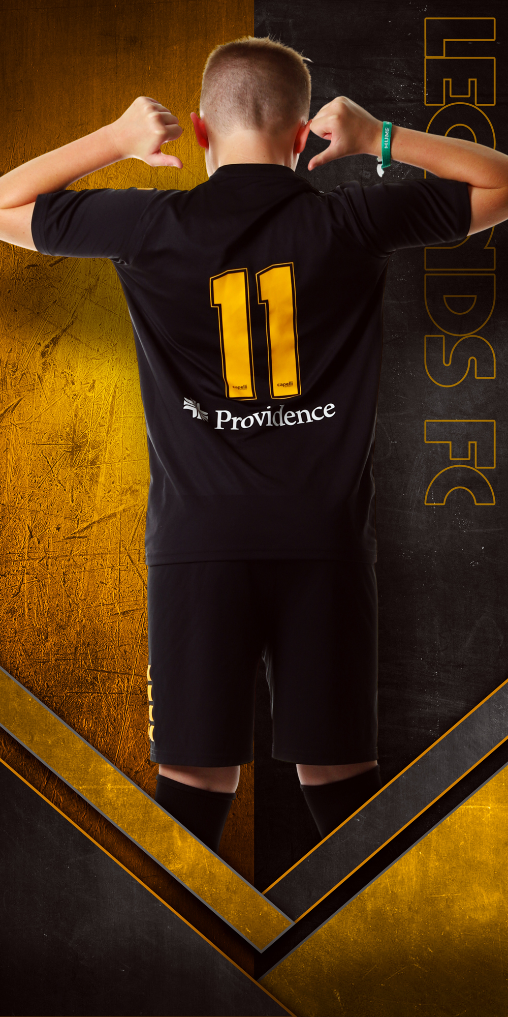 back of boy soccer player pointing at jersey number on two color themed background 0303
