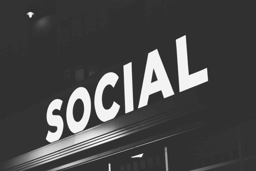 black and white photo showing neon letters spelling "Social" diagonally across the image