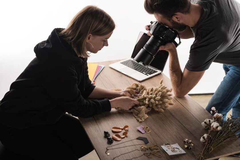 female holding styled jewelry products for male photographer