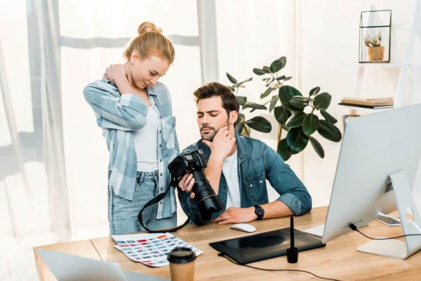 woman and man looking at camera reviewing photos