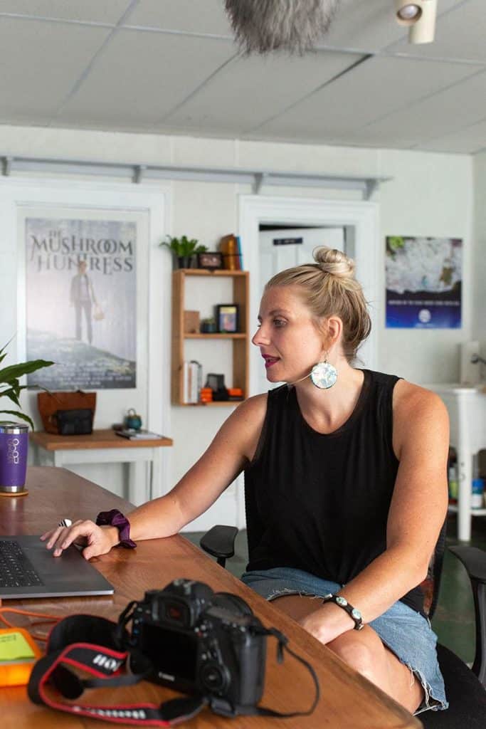 woman sitting at desk with camera computer