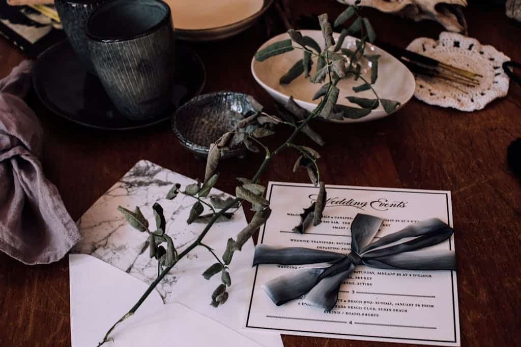 Wedding invitation on table with utensil and decorations