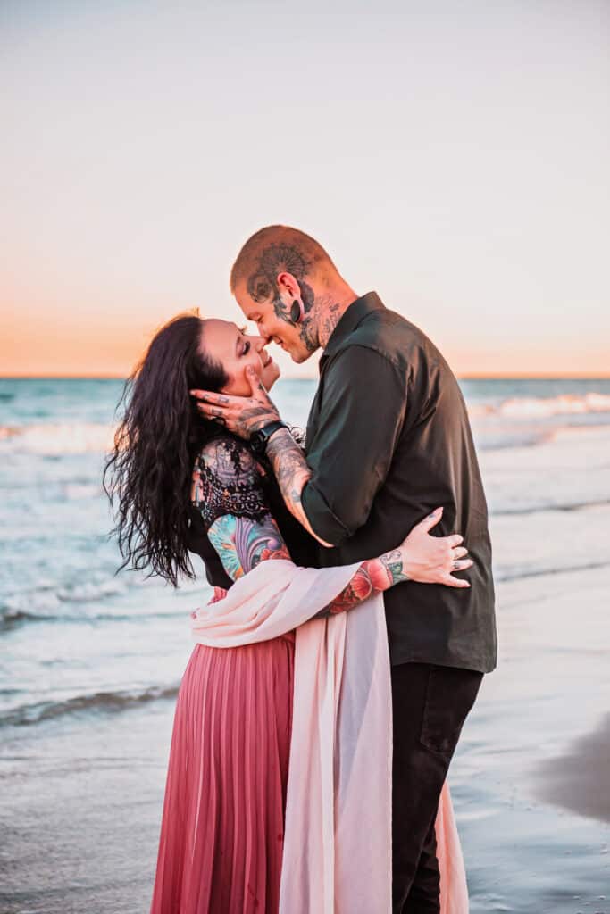 Portrait by JS Portrait Studio Delray Beach of a woman and man with tattoos embracing on the beach, their faces close together