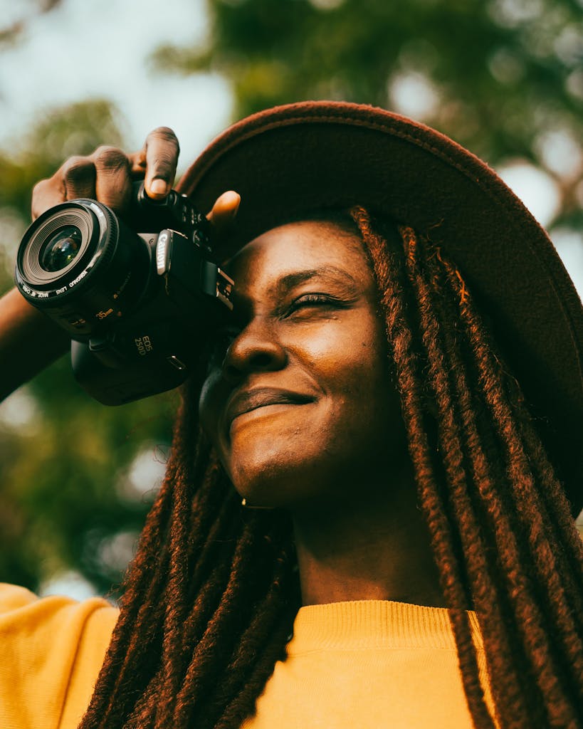 Smiling Woman with dreadlocks Taking Pictures with a dslr Camera