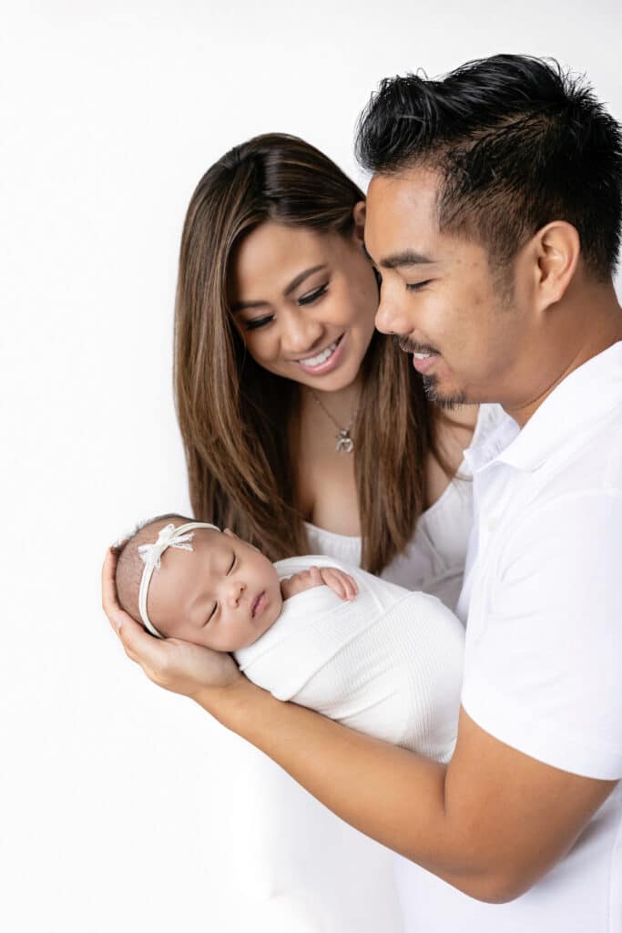 Couple holding newborn baby photographed by Stephanie Schnautz